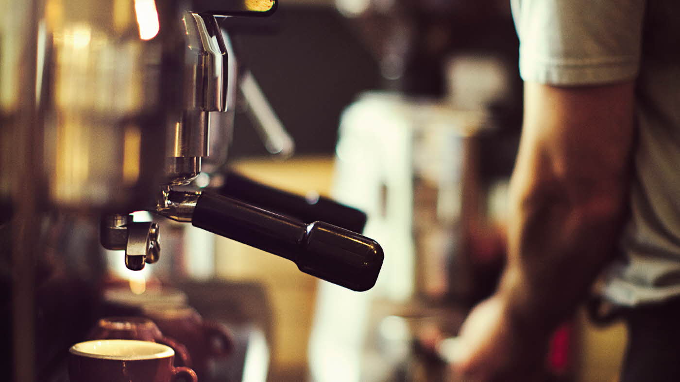Mann står å lager kaffe