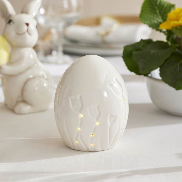 et hvit kermaikk egg med tulipan motiv som lyser