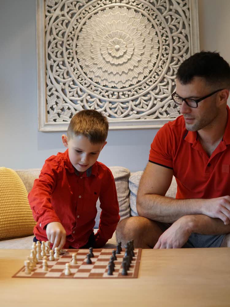 Mann og barn som spiller sjakk