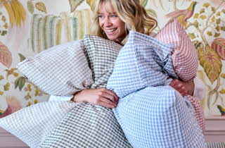 Dame holder flere puter med rutete krepp-trekk i blått, grønt og rosa.