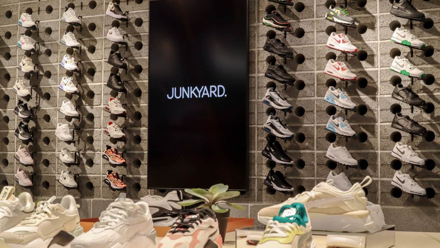 Vegg med sneakers, svart skjerm med Junkyard logo