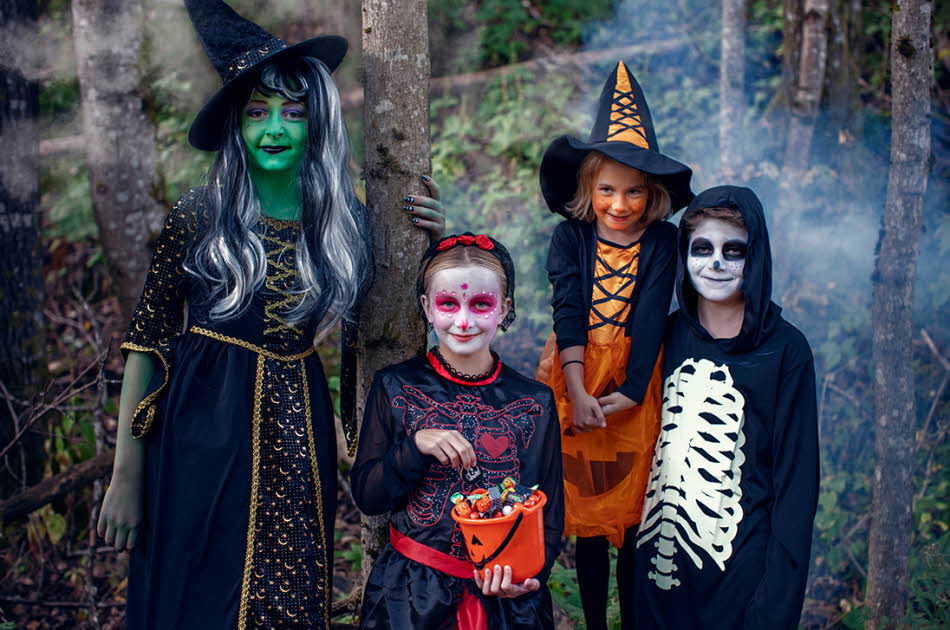Barn står utkledde i kostymer i forbindelse med Halloween