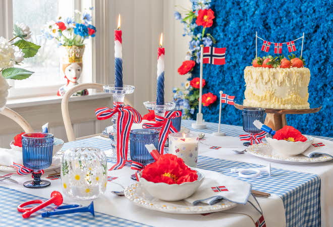 Festlig borddekking med norske flagg og kake.