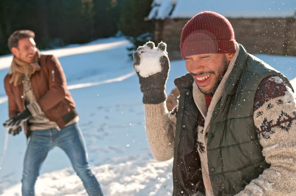 To menn i vinterklær kaster snøball  