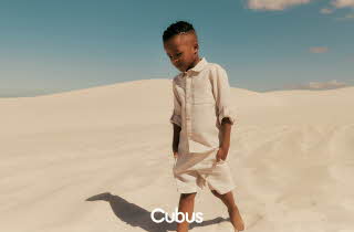 Et barn står i en ørken, han har på seg beige linklær