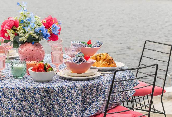 Fargerikt bord dekket til mat med vase med blomster