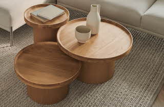 Tre runde bord i forskjellig størrelse brukt som stuebord