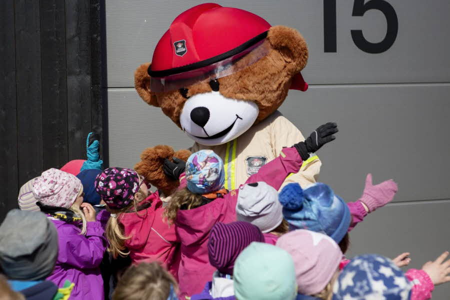 Maskot bamse med barn rundt