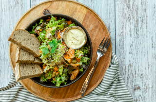 trefat med skål med salat, dressing og skiver til fra baker brun