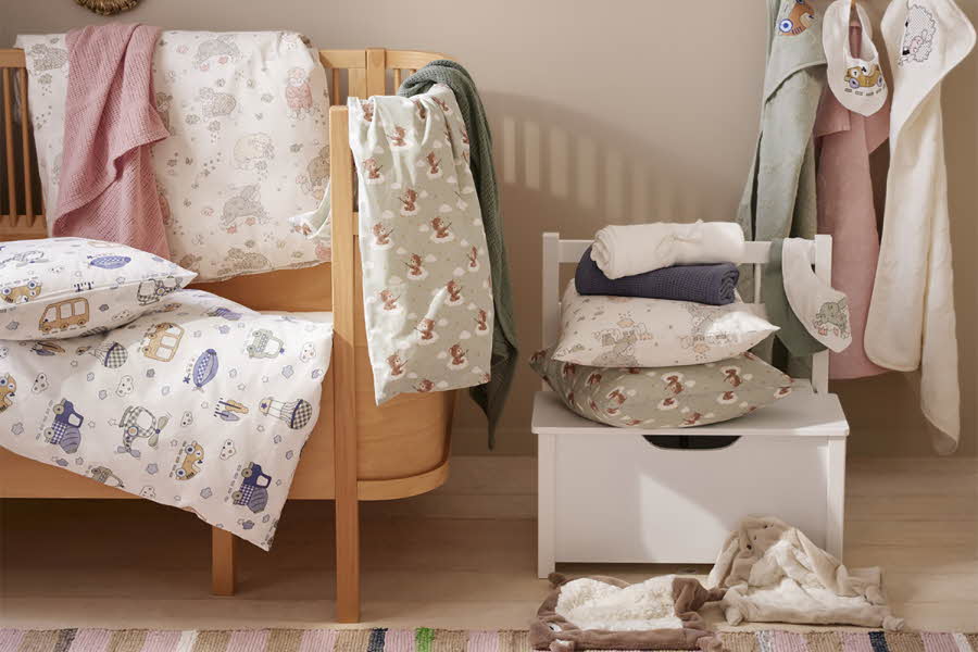 rom med barneseng, dyner, laken, puter, håndklær og leker til baby eller barn