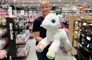 Dame som holder en stor enhjørningsbamse