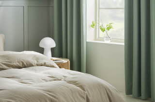 Et grønt soverom med grønne gardiner