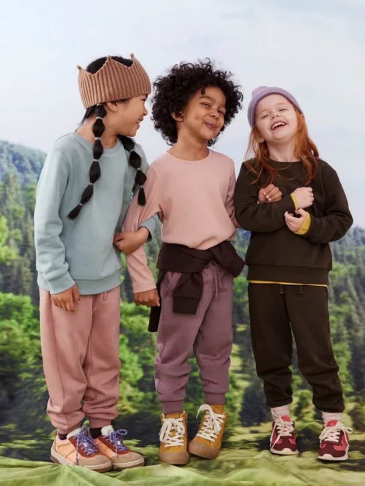 Tre smilende barn i skogen