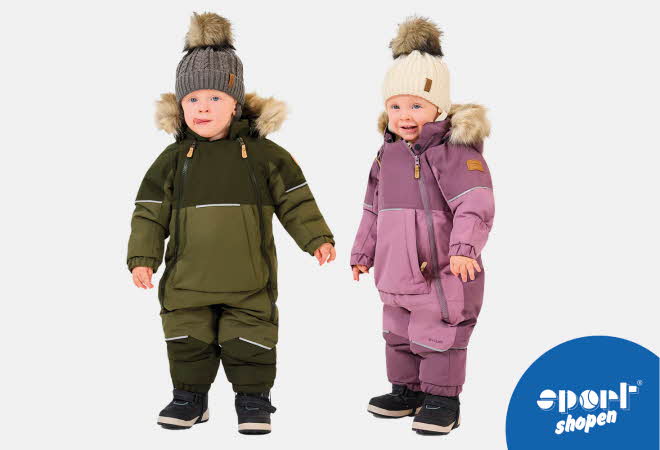 To barn står i vinterdresser med pelskant på hetten og varme støvler.