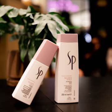 To produkter fra SP utstilt med en potteplante i bakgrunn