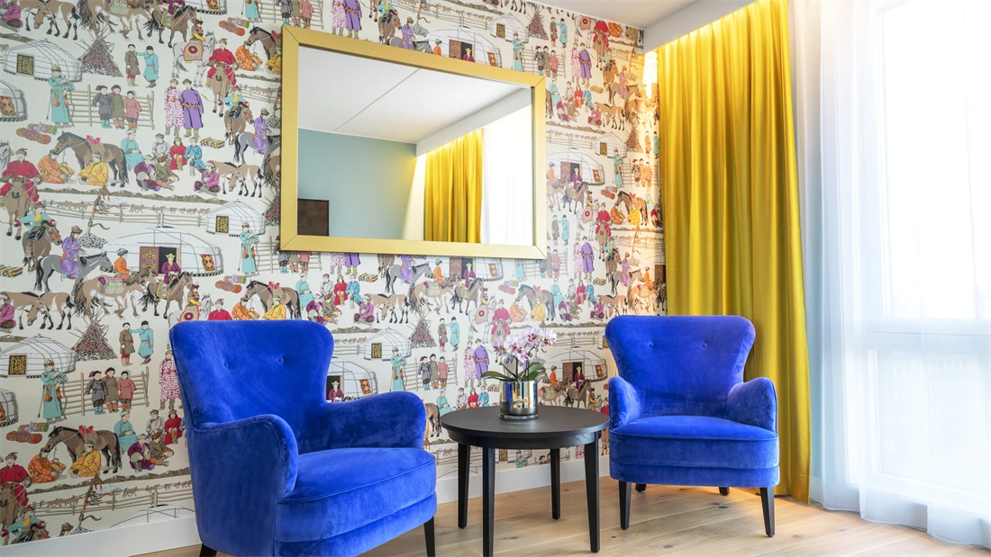 Dekorativ tapet, speil med gullramme og to sitteplasser rom på Thon Hotel Storo