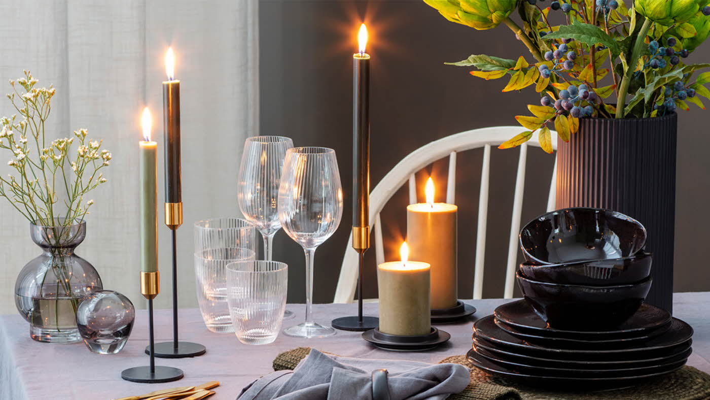 Dekt bord med lys, plante og glass