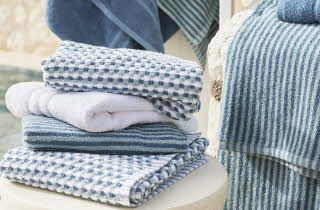 En bunke med hvite og blå håndklær oppe på en krakk
