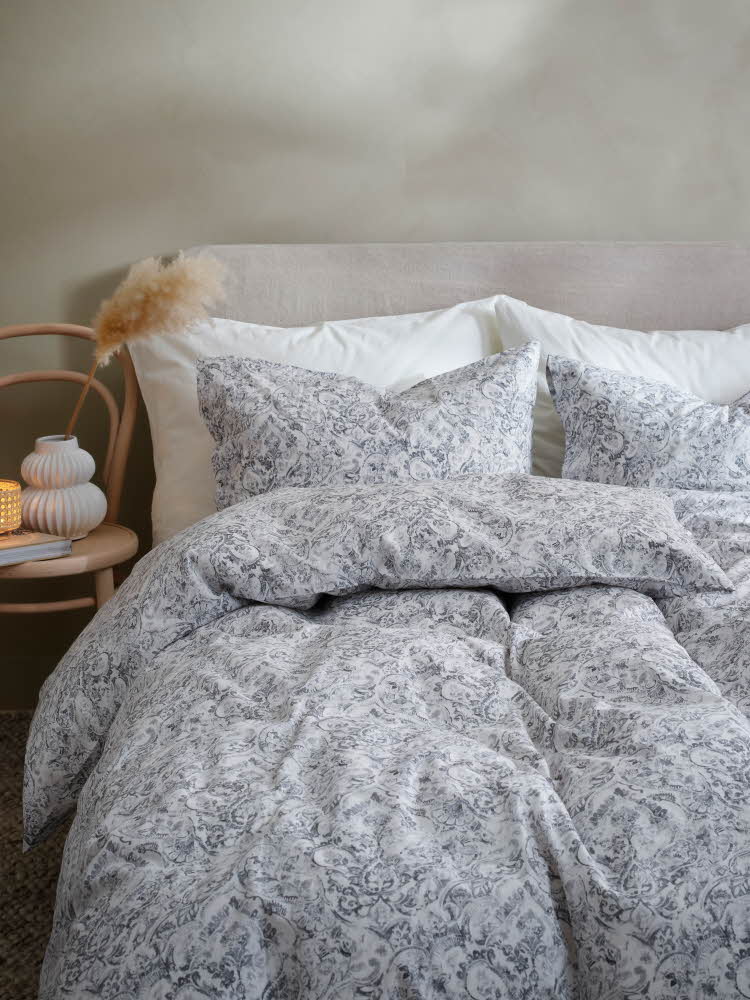 lyst sengetøy med grå blomster