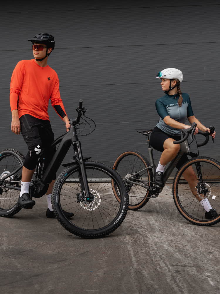 Nærbilde sykkel og sykkelsko Jente og gutt i treningstøy og hjelm på sykler utendørs
