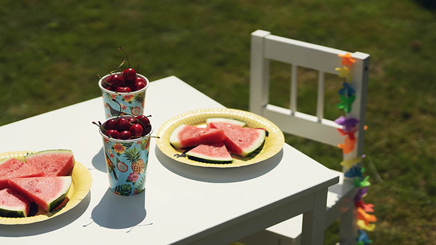 Barne-bord dekket til sommerfest med sommertallerken, melon og kirsebær