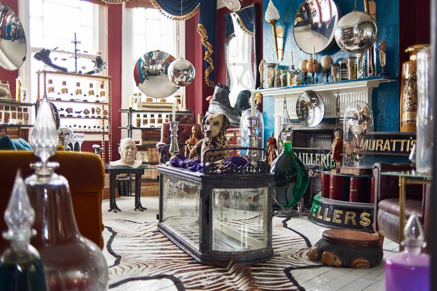 Eklektisk stue fullt av møbler og antikviteter
