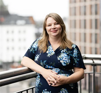 Portrett av Anna Marie Fjeld. Hun står foran et gjerde. 