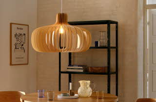 En stor, rund lampe som henger over et spisebord