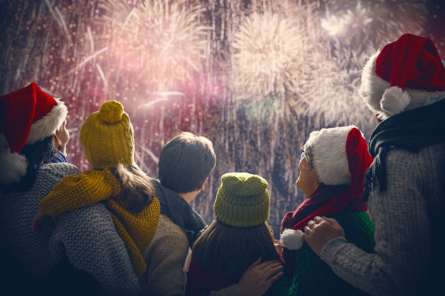 Folk med nisseluer ser på fyrverkeri