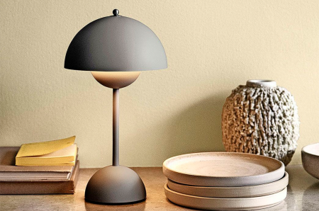 Beige lampe og noen fat står på et bord