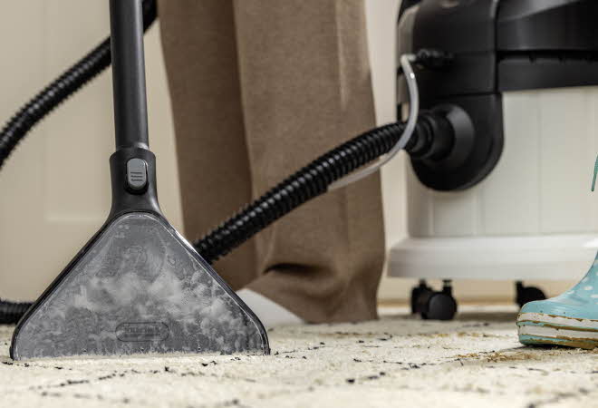 Rengjøringsmaskin som vasker et teppe.