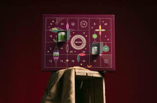 Helios adventskalender med lilla design og små åpne luker.