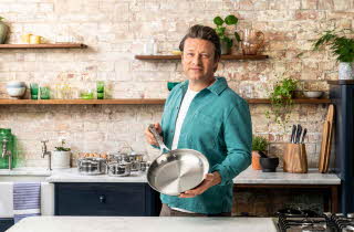 Jamie Oliver i turkis skjorte som holder stekepanne