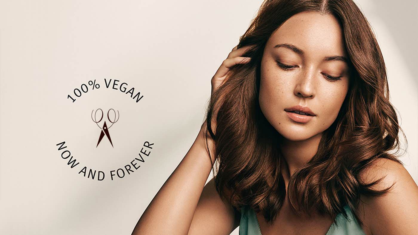 Dame som tar seg på håret og teksten "100% vegan - now and forever"