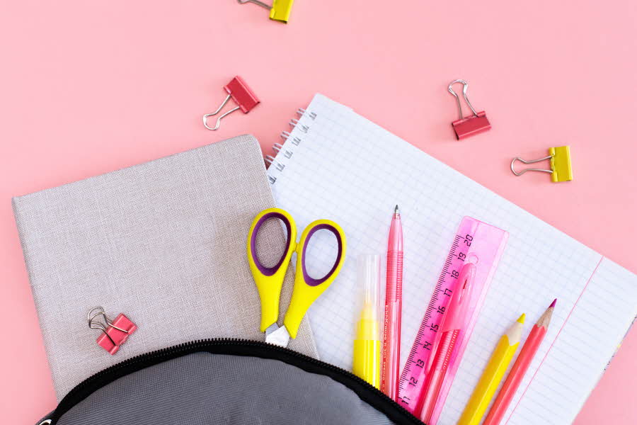 pennal med gul saks, highlighter, blyant og rosa pen, blyant og linjal