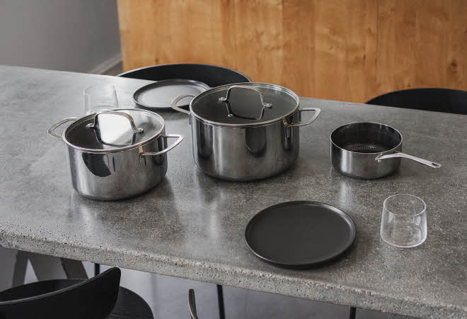 Et kjøkkenbord med tre forskjellige gryter.