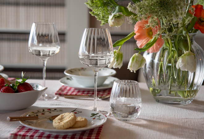 Et bord dekket til middag, med en store vase med blomster