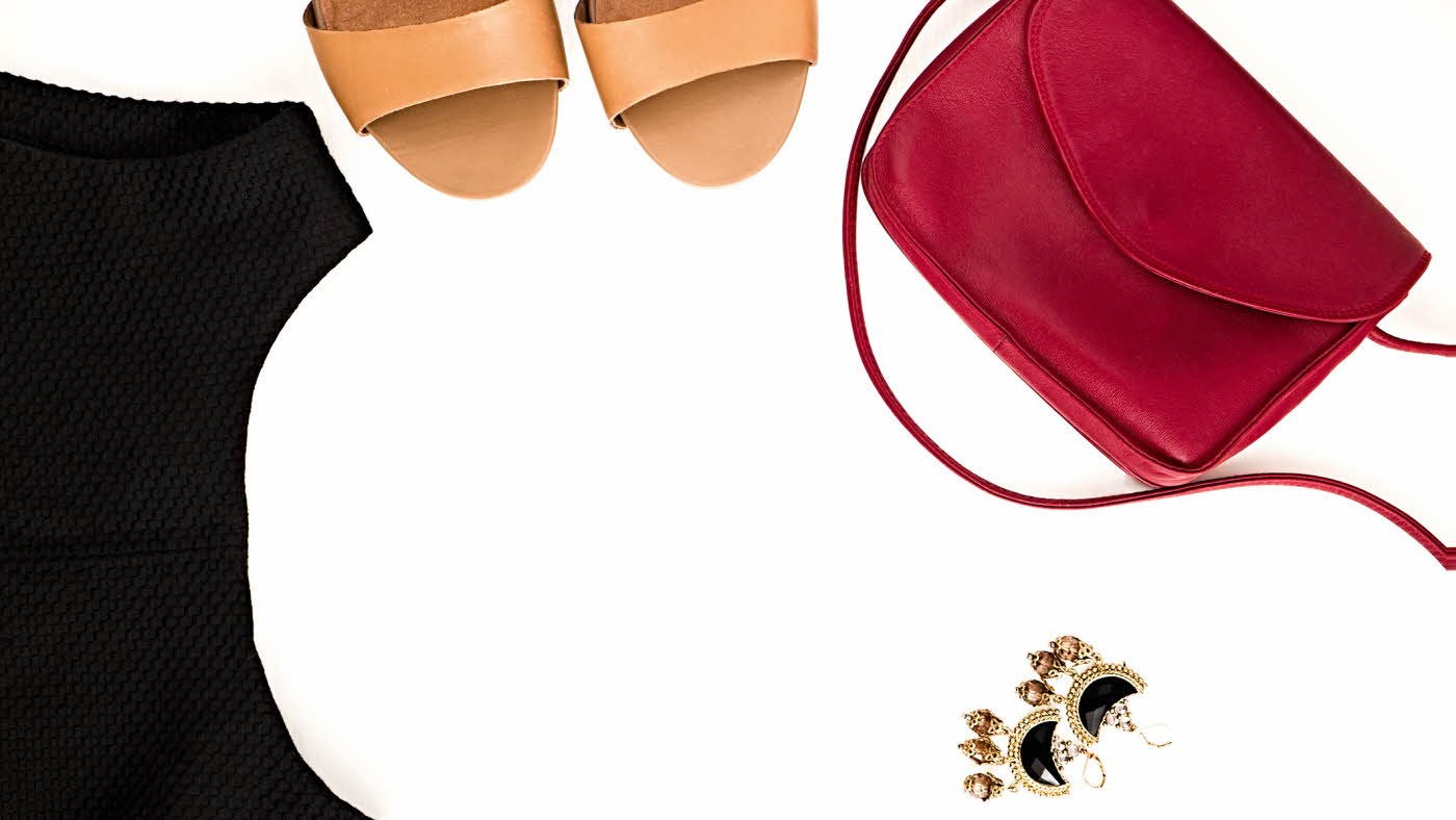 Flat lay av burgunder veske, øredobber, beige høyhælte sko og sort skole