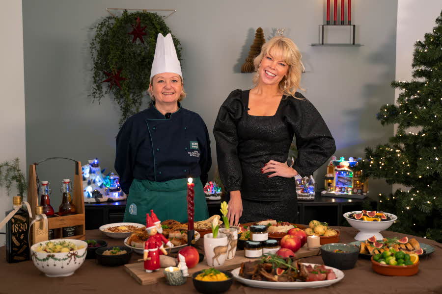 En kokk og Marianne Jemtegård som smiler bak et dekket bord med mat