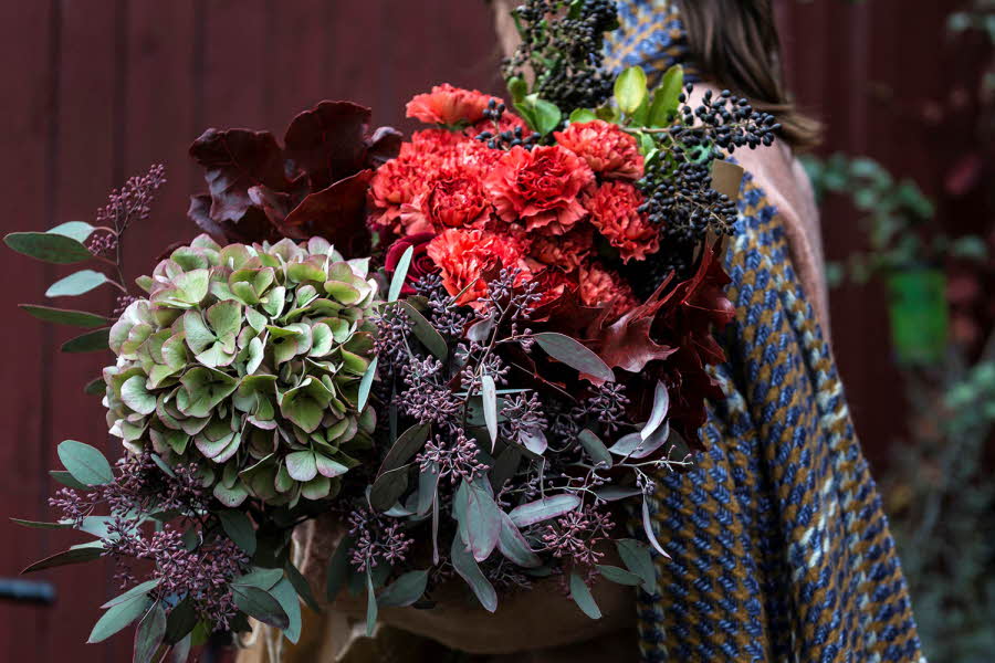 Dame som holder flere blomster buketter