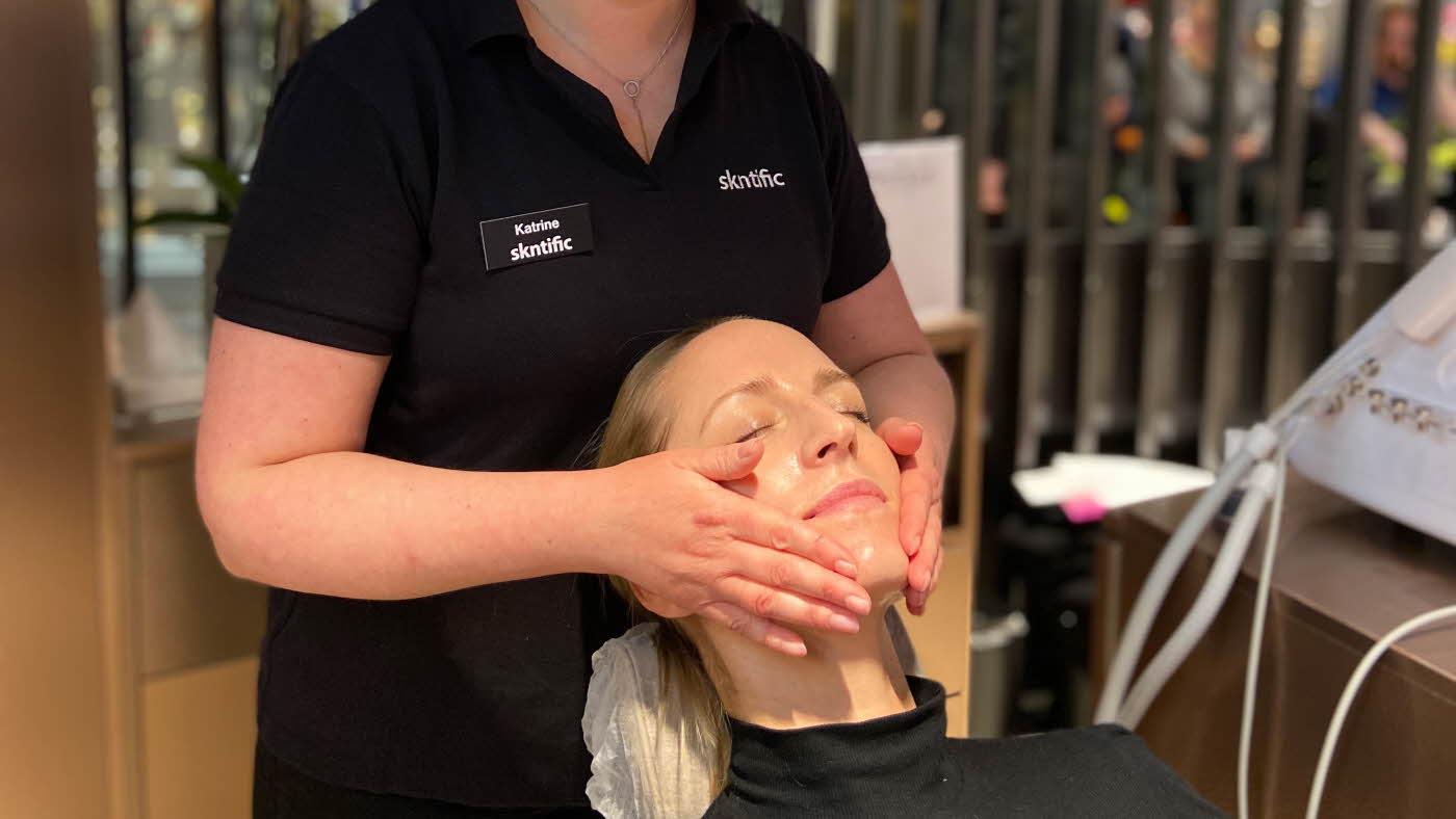Dame får ansiktsbehandling hos skintific
