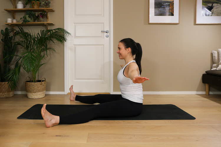 Anna viser Pilates-øvelser på treningsmatte på gulvet
