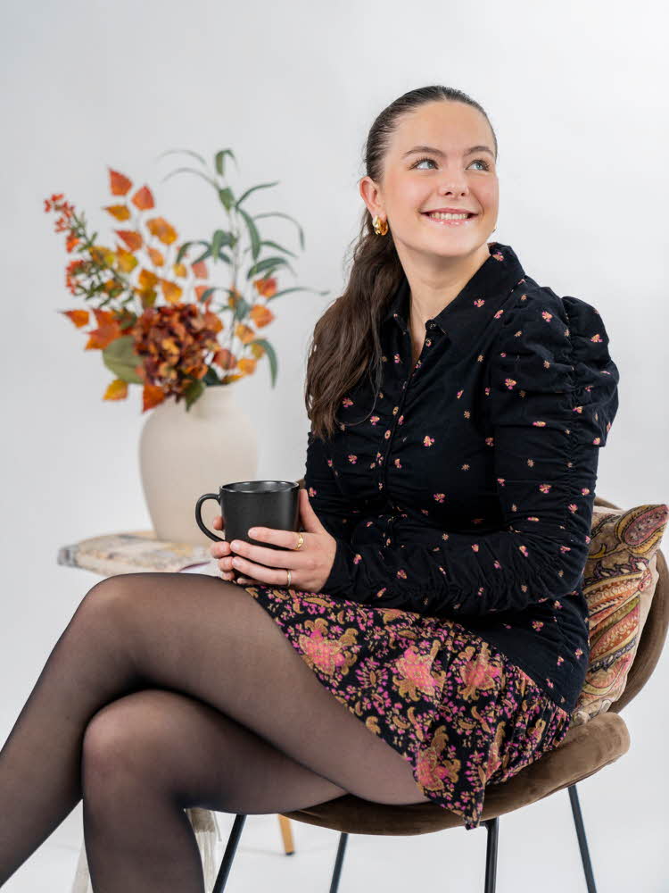 dame som drikker kaffe i blomstrede klær