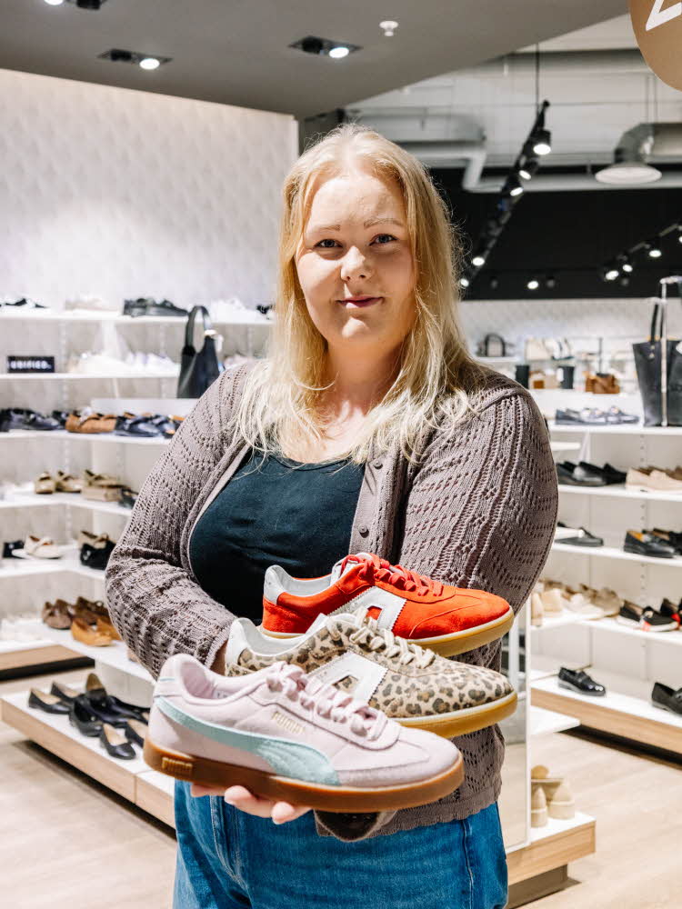 Dame som holder sneakers