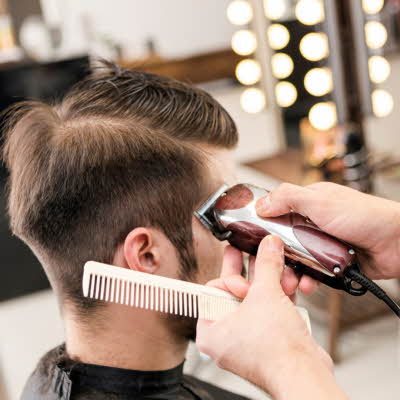 frisør som barberer håret til en mann