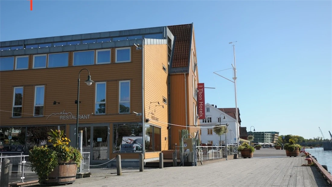Fasaden til Thon Hotel Tønsberg Brygge med gule vegger og plassering på Brygga i Tønsberg sentrum.