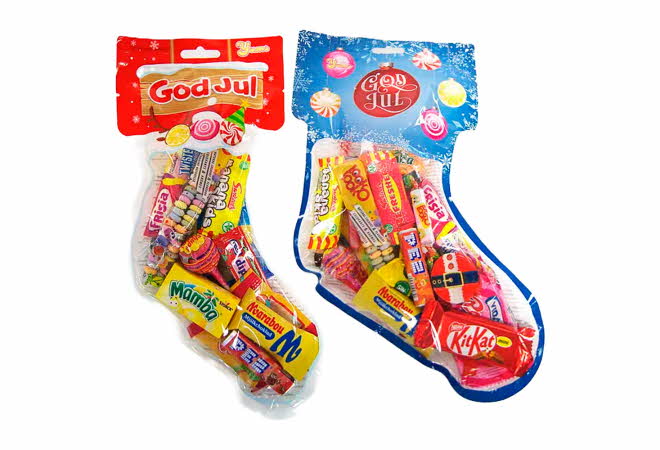 To gjennomsiktige julestrømper fylt med assortert godteri og merket med «God Jul».