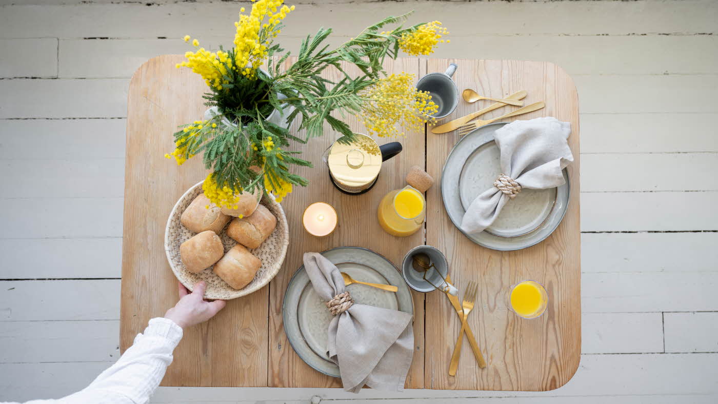 Bord dekorert med service, mat og blomster