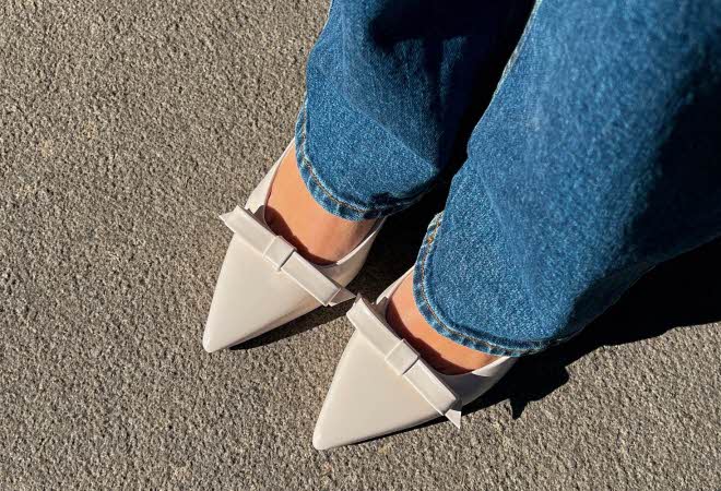 Nærbilde av føttene til en kvinne i jeans med hvite pensko