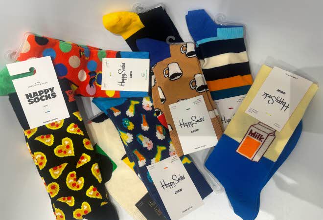 Forskjellige farvede Happysocks ligger på hvit bakgrunn